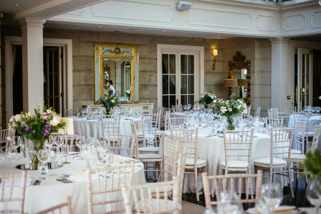 A Summer Wedding reception at Tankardstown House, where the large room is elegantly adorned with white tables and chairs.