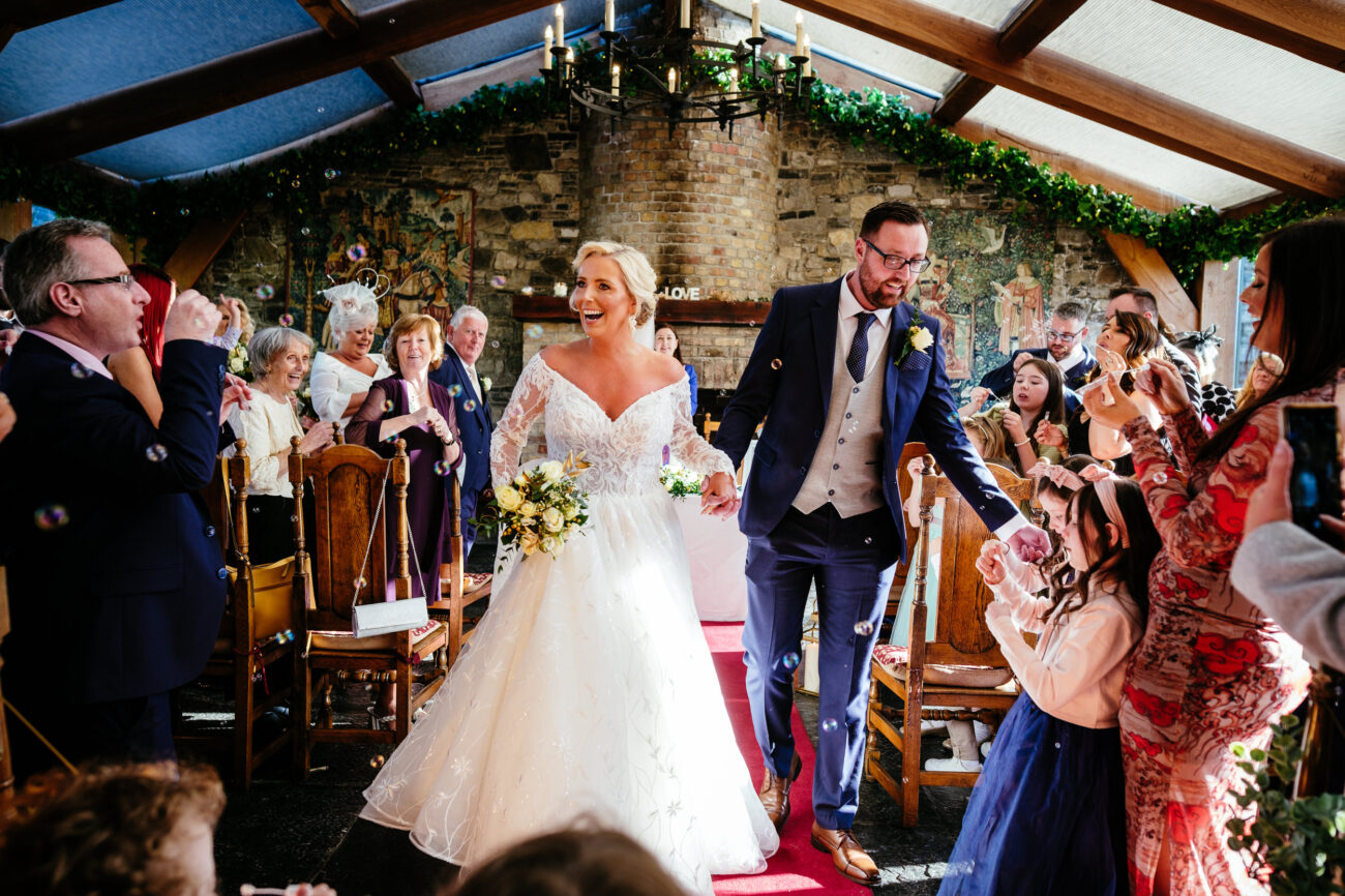 A bride and groom walking down the aisle at their Barberstown Castle wedding.