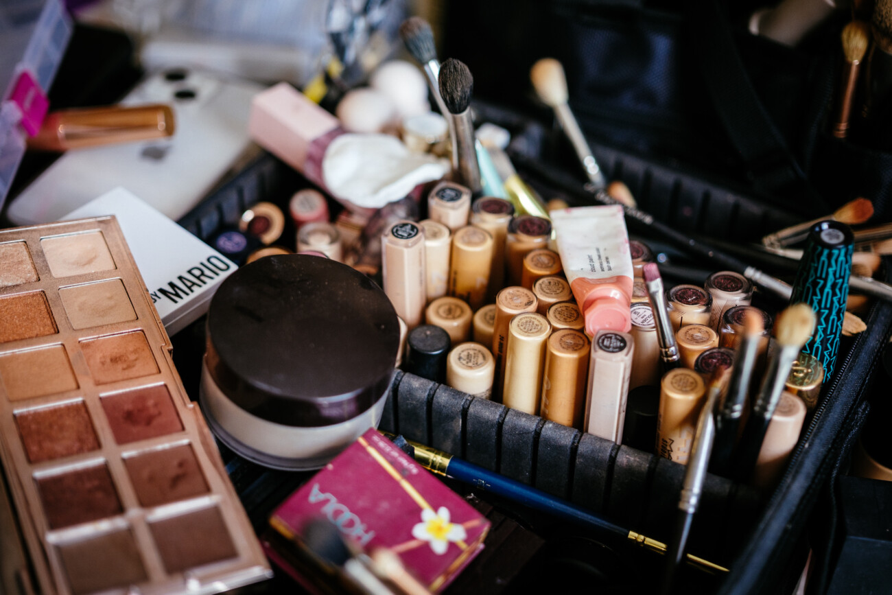 Tara and Darren’s Unforgettable Wedding at Bellingham Castle 18 Various make-up items, including foundation bottles, brushes, an eyeshadow palette, and lipsticks, are arranged together in a black make-up case—perfect for preparing a flawless look for a wedding at Bellingham Castle.