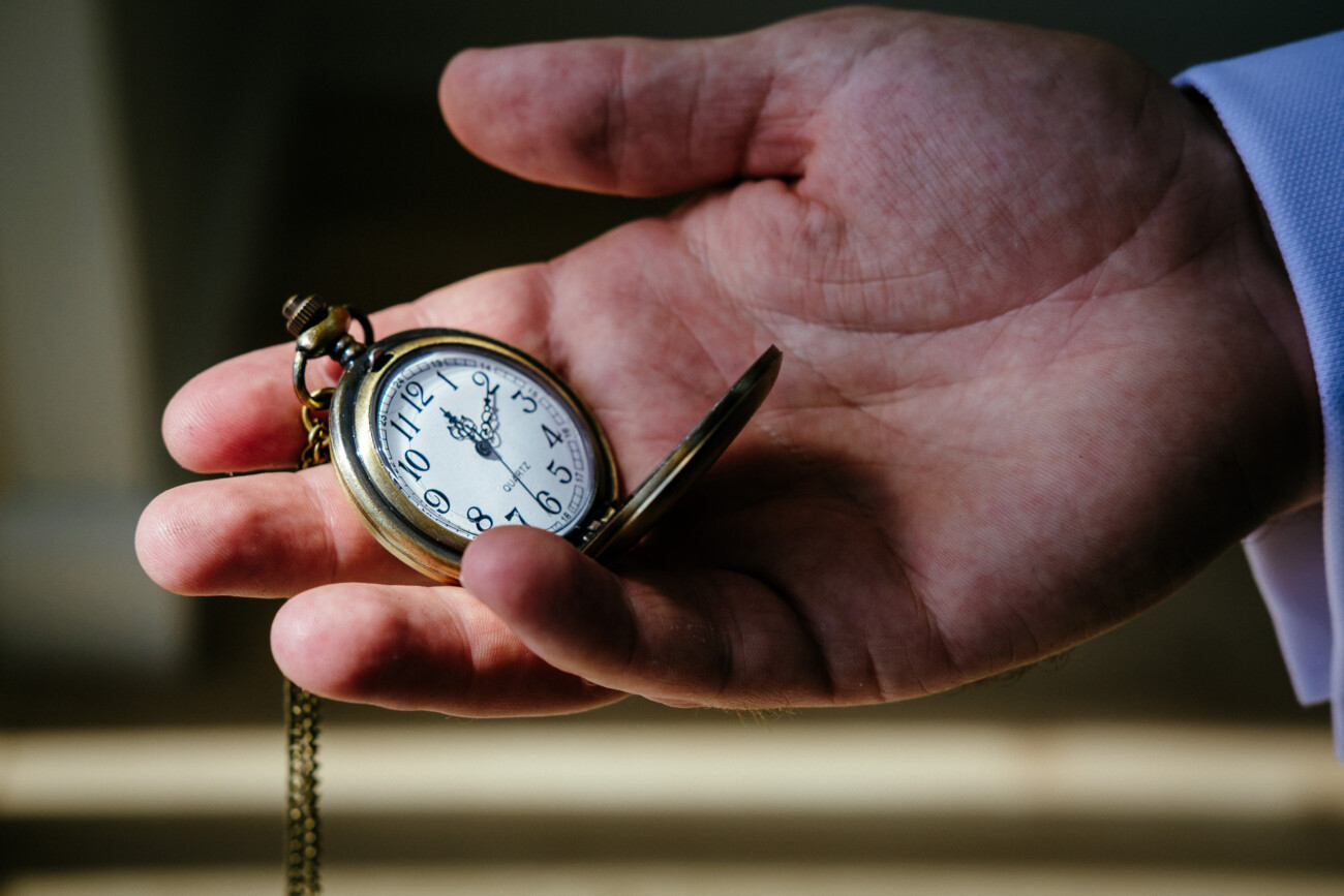 Tara and Darren’s Unforgettable Wedding at Bellingham Castle 21 A person holds an open pocket watch in their palm; the watch shows the time as 8.25, perhaps marking a meaningful moment before a wedding at Bellingham Castle.