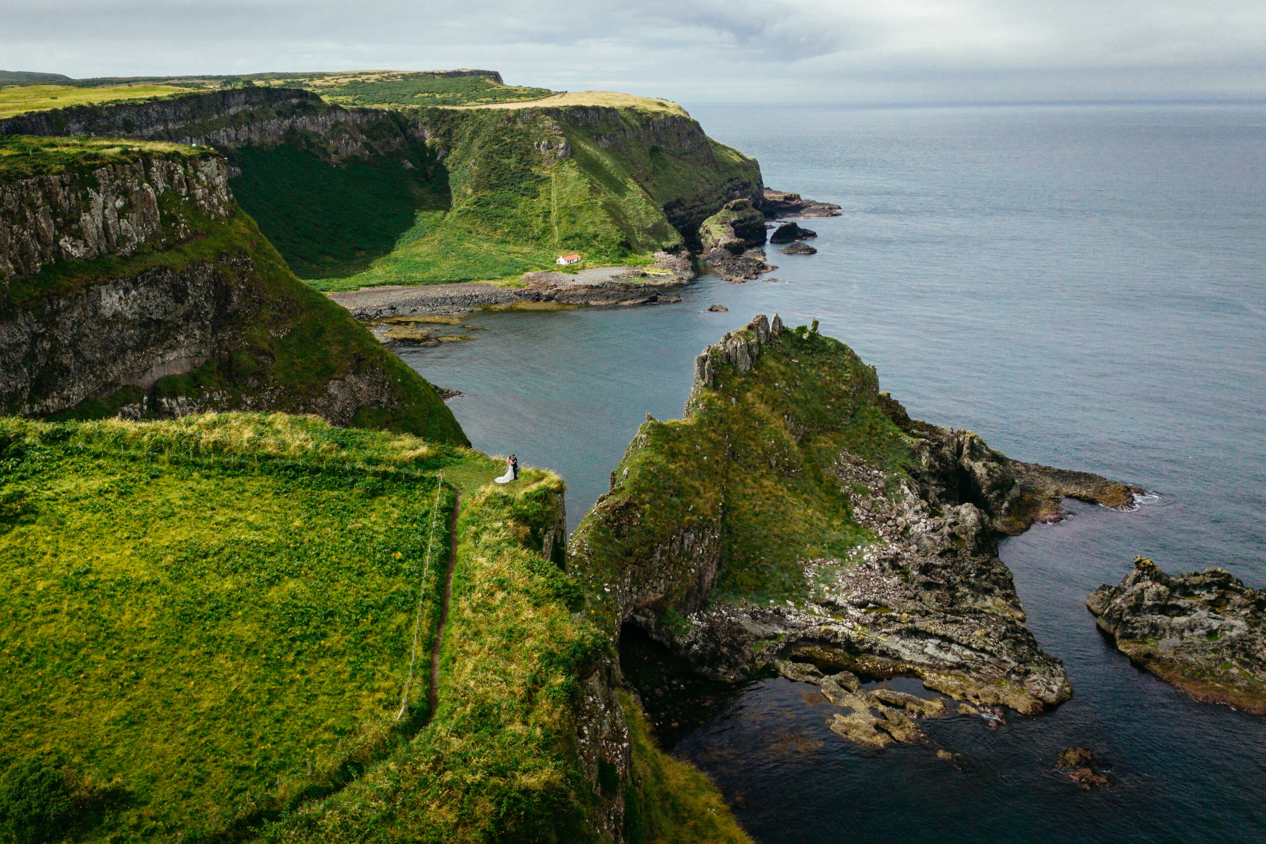 Northern Ireland Elopements 1 A couple stand together on a clifftop above the Atlantic on the Causeway Coast in Northern Ireland during their elopement