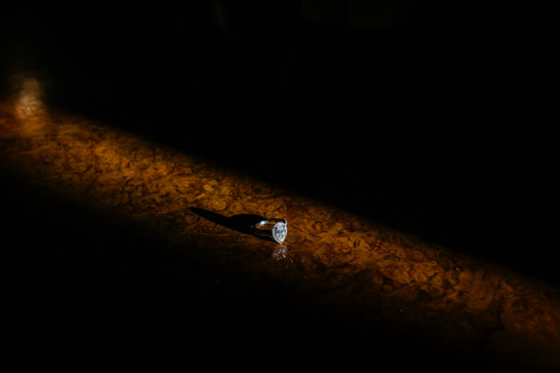 A pear-shaped diamond engagement ring in a beam of light at Howth Castle