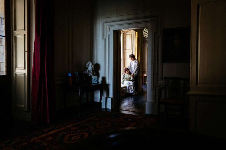 A woman sitting on a window sill beside her partner at Howth Castle