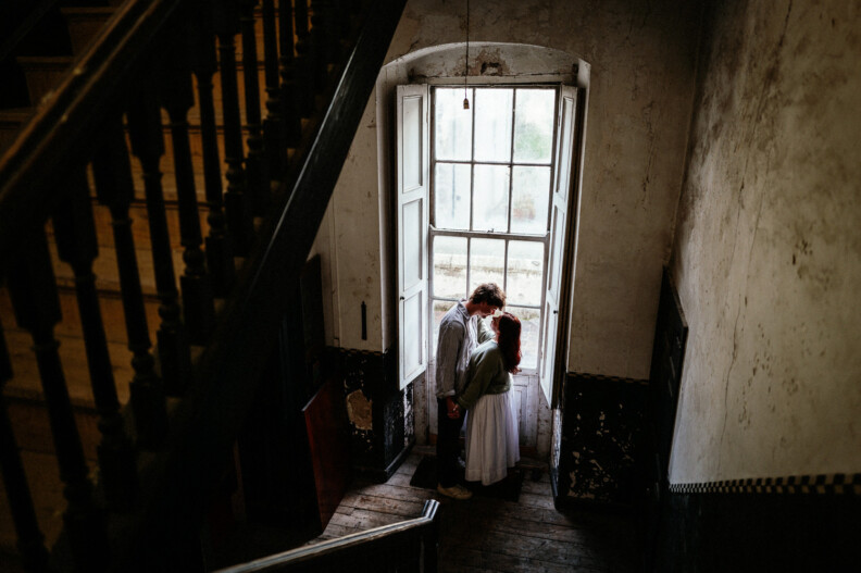 A couple holding hands by a window inside Howth Castle