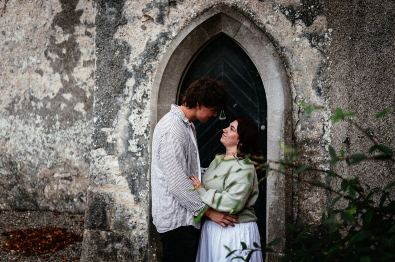 A couple face to face in front of an arched stone doorway at Howth Castle